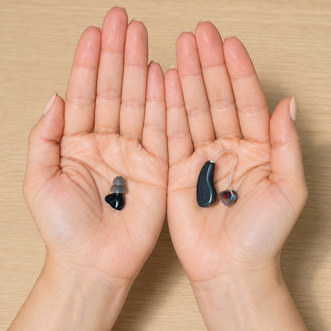 CIC and RIC hearing aids displayed side by side in open hands for size and design comparison.