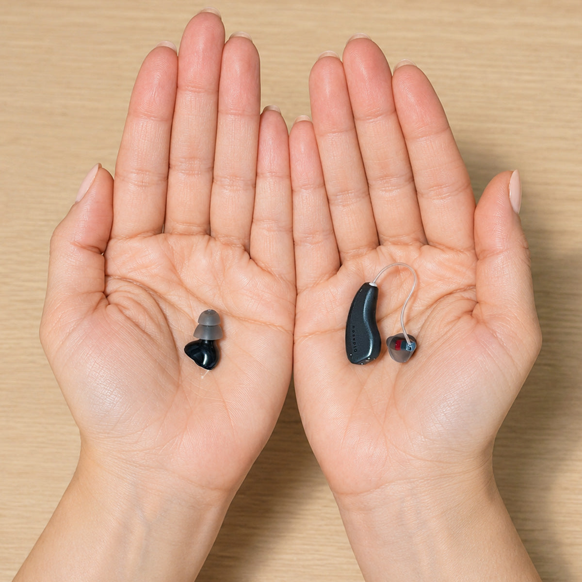 CIC and RIC hearing aids displayed side by side in open hands for size and design comparison.